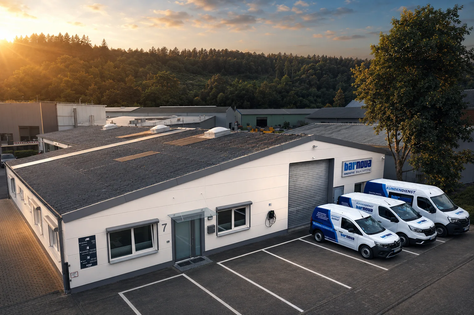Luftaufnahme des Barnova Firmengebäudes mit Kundendienstfahrzeugen im Abendlicht